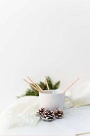 Photo Of Pine Cones Near A White Cup