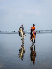 Men Riding Horses On Sea Shore