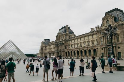 People Walking Around The Louvre In Paris