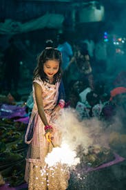 Young Girl Celebrating With Sparkler At Night Celebration