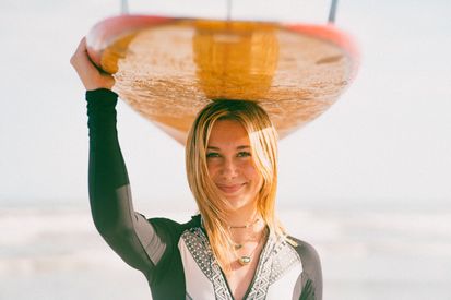 Young Woman Surfer With Surfboard On The Beach