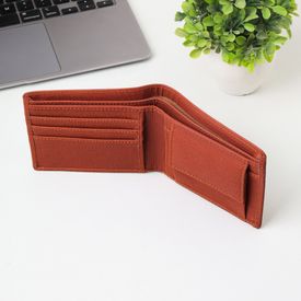 Open Brown Wallet On White Desk With Laptop And Plant