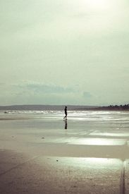 Lone Figure Walking On Tranquil Vietnamese Beach