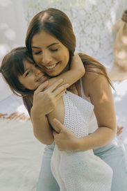 Loving Mother And Daughter Embrace Outdoors
