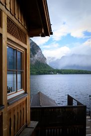Scenic View Of Alpine Lake And Wooden Cabin