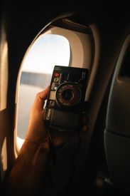 Vintage Camera Held By Airplane Window