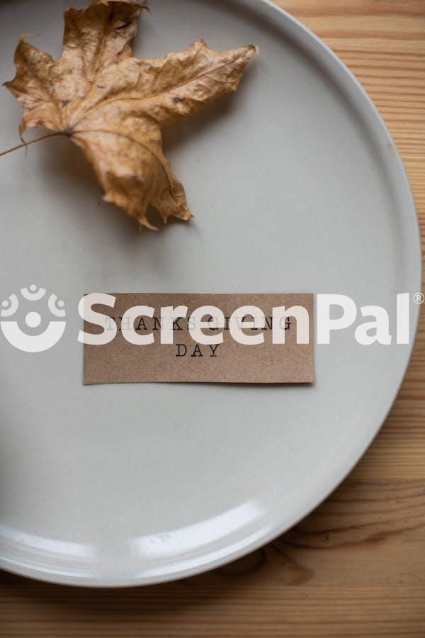 Plate With Carton Postcard And Dry Leaf