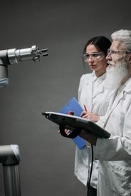 Scientists Looking At A Robot Machine